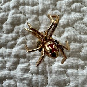 Noble Breed gold spider lapel pin.